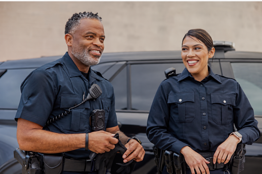 Uniformed police officers beside their patrol vehicle
